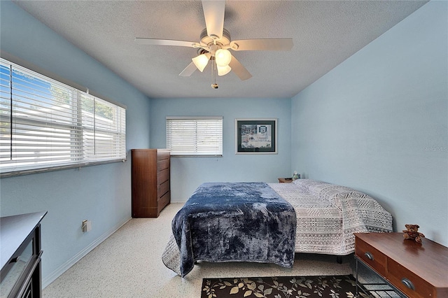 bedroom featuring baseboards, a ceiling fan, a textured ceiling, and speckled floor