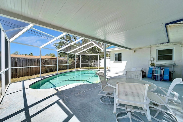 view of pool with glass enclosure, a patio area, a fenced backyard, and a fenced in pool