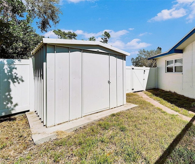 view of shed featuring fence private yard and a gate