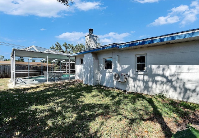 rear view of property featuring a fenced in pool, a chimney, a lanai, fence, and a yard