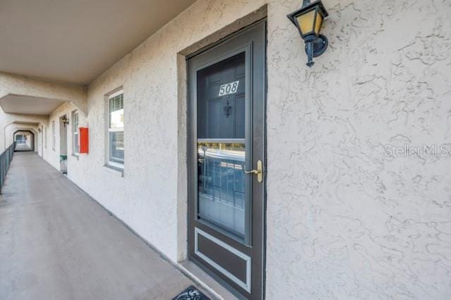 property entrance with stucco siding