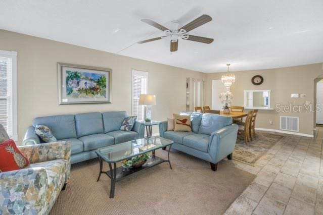 living room featuring a ceiling fan, visible vents, and baseboards