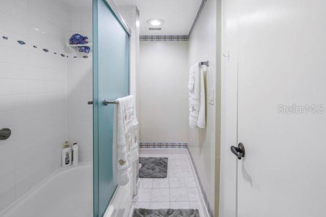 bathroom with enclosed tub / shower combo and tile patterned floors