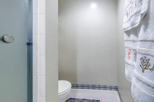 bathroom with toilet and a shower with door