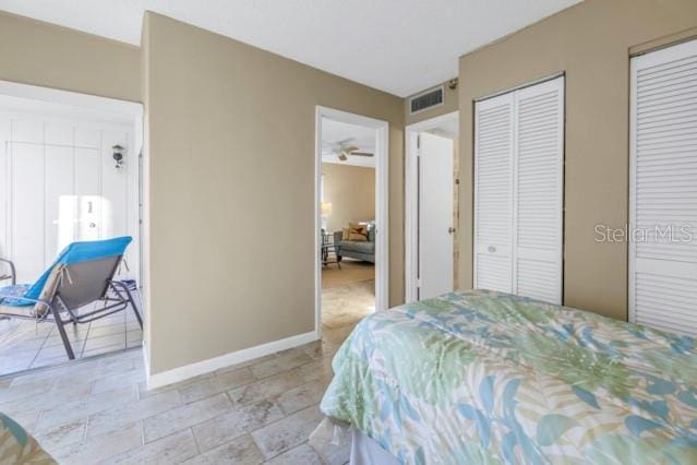 bedroom with visible vents, baseboards, and two closets
