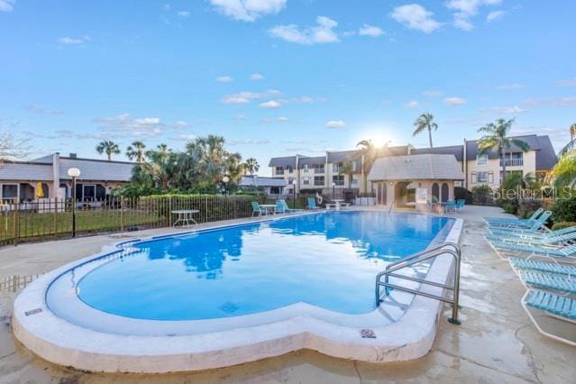 pool with a residential view, fence, and a patio