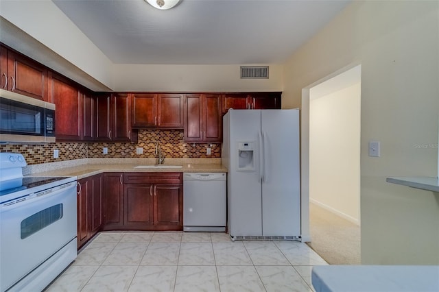 kitchen with white appliances, a sink, visible vents, dark brown cabinets, and backsplash