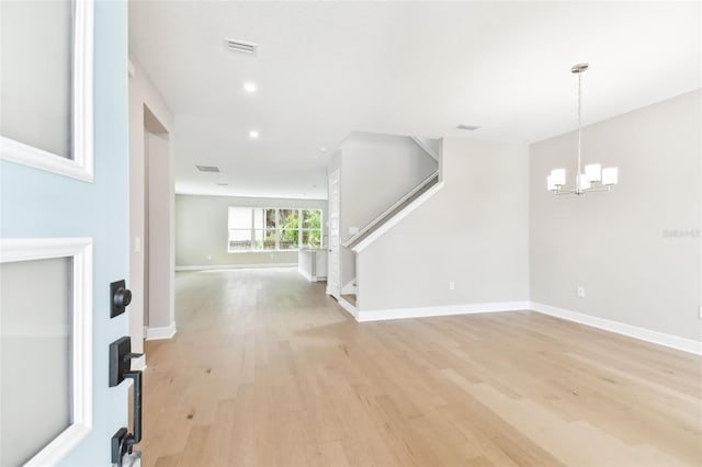 unfurnished living room with recessed lighting, a notable chandelier, baseboards, stairway, and light wood-type flooring