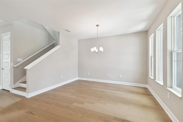 empty room with stairs, baseboards, visible vents, and light wood-style floors