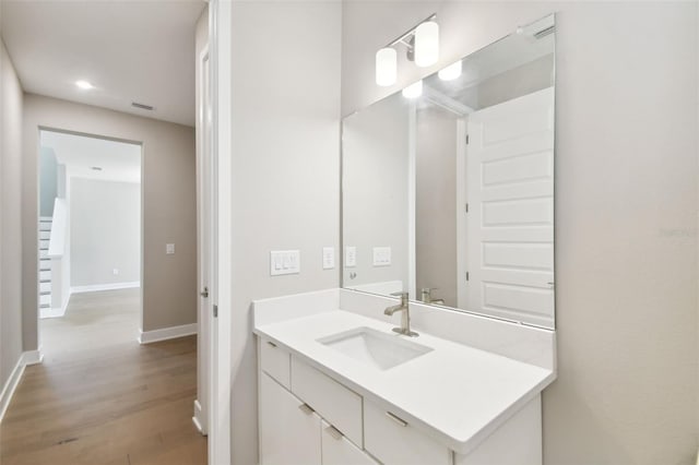 bathroom featuring vanity, baseboards, and wood finished floors