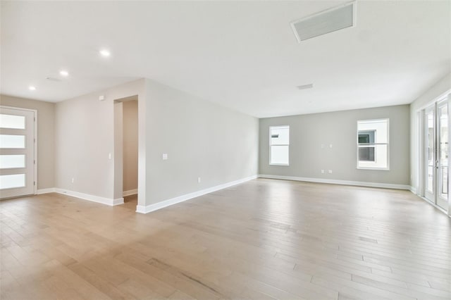 unfurnished room with light wood finished floors, recessed lighting, baseboards, and french doors