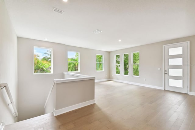 empty room featuring recessed lighting, wood finished floors, visible vents, and baseboards