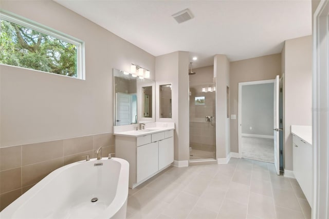 full bathroom featuring a freestanding tub, tile patterned flooring, visible vents, vanity, and a shower stall