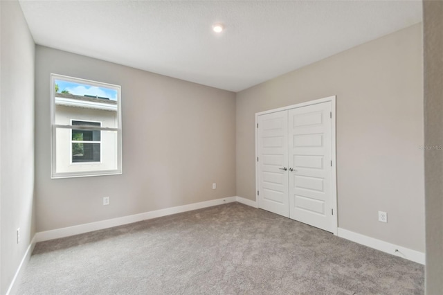 unfurnished bedroom featuring a closet, carpet flooring, and baseboards