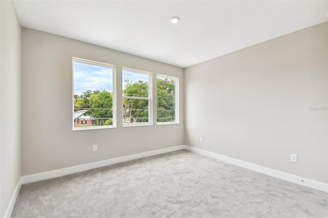 carpeted empty room featuring baseboards