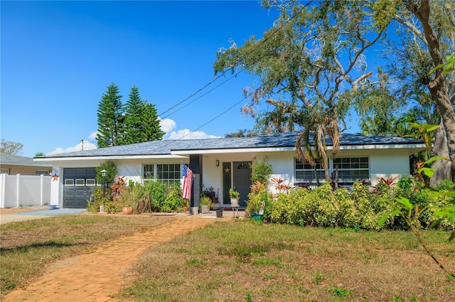 single story home with a garage, fence, a front lawn, and stucco siding