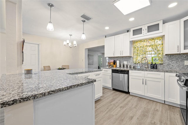 1131 60th Ave S, Saint Petersburg, FL 33705 - kitchen featuring appliances with stainless steel finishes, a sink, a chandelier, white cabinetry, and tasteful backsplash