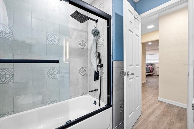 1131 60th Ave S, Saint Petersburg, FL 33705 - ensuite bathroom featuring shower / bath combination with glass door, wood finished floors, and baseboards
