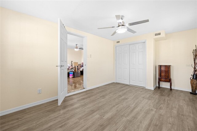 1131 60th Ave S, Saint Petersburg, FL 33705 - unfurnished bedroom featuring light wood-style floors, a closet, baseboards, and ceiling fan