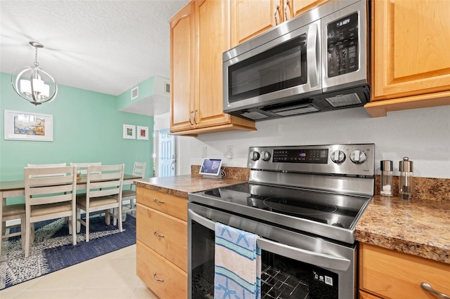 kitchen featuring a textured ceiling, light tile patterned floors, stainless steel appliances, visible vents, and light brown cabinetry