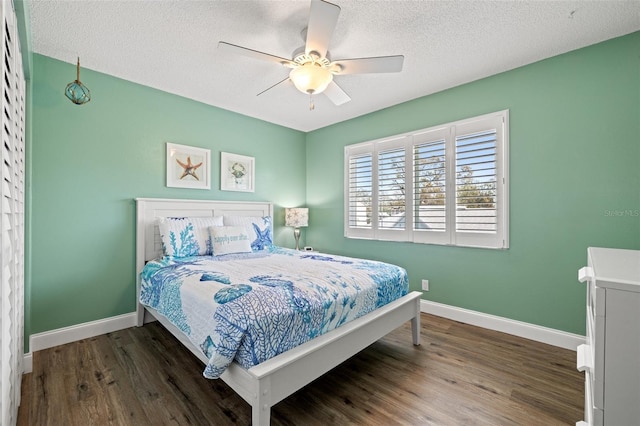 bedroom with a textured ceiling, ceiling fan, wood finished floors, and baseboards