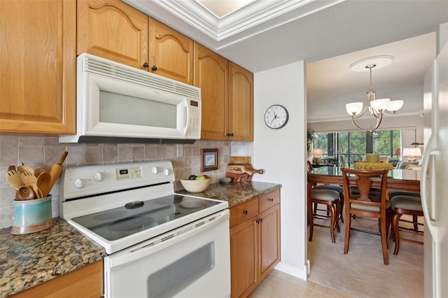 kitchen featuring crown molding, backsplash, a chandelier, dark stone counters, and white appliances