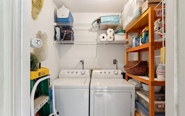 clothes washing area featuring laundry area, a textured ceiling, and washing machine and clothes dryer