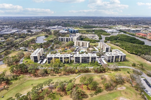 drone / aerial view with a water view, view of golf course, and a view of city