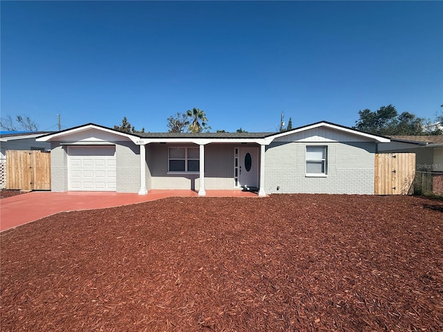 single story home with brick siding, driveway, an attached garage, and fence