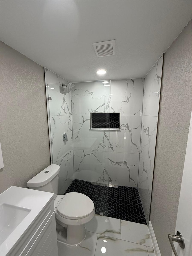 bathroom featuring a marble finish shower, visible vents, a textured wall, toilet, and marble finish floor