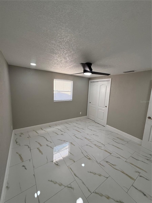 unfurnished bedroom featuring marble finish floor, visible vents, and baseboards