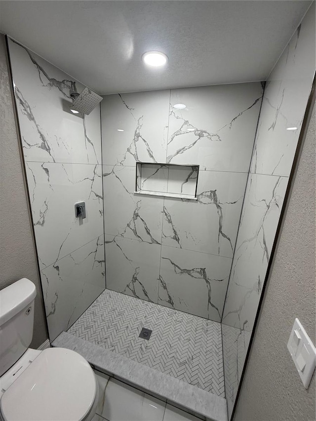 bathroom with toilet and a shower stall