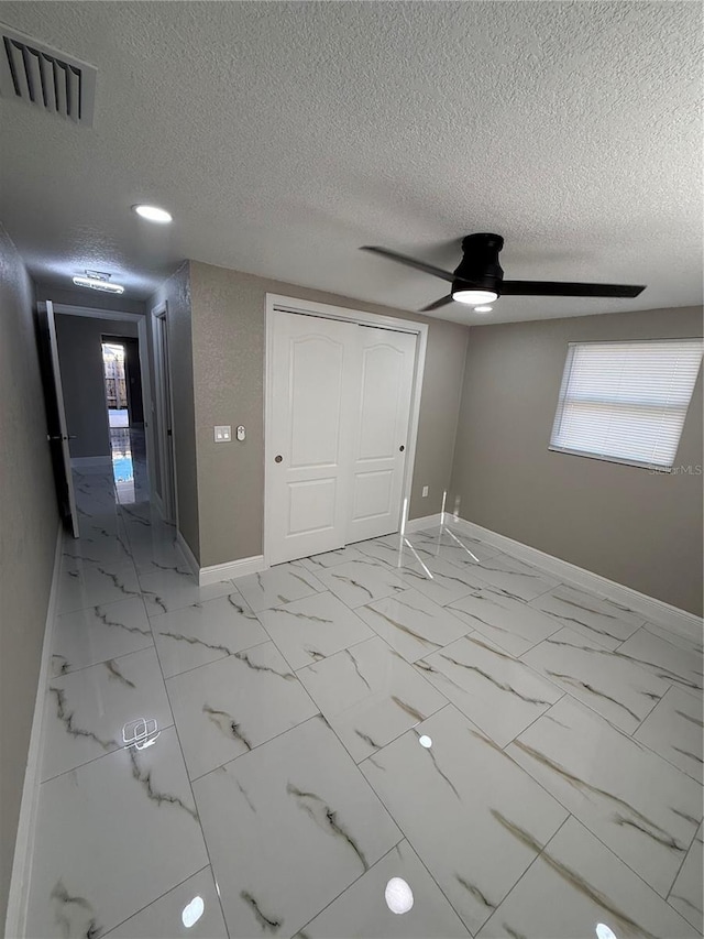 interior space featuring marble finish floor, baseboards, visible vents, and a closet