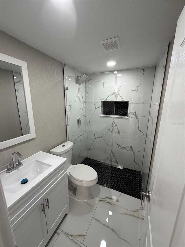 full bath with marble finish floor, a marble finish shower, visible vents, toilet, and vanity