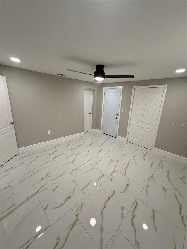 interior space with visible vents, baseboards, a ceiling fan, marble finish floor, and a closet