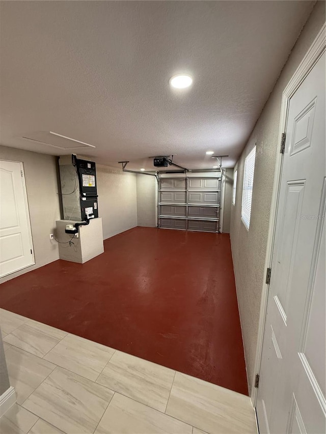 garage with a textured wall and a garage door opener