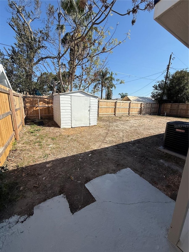 view of yard with central AC, a shed, an outdoor structure, and a fenced backyard