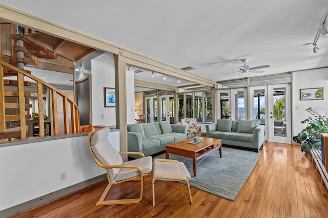 interior space with stairs, french doors, rail lighting, and hardwood / wood-style flooring