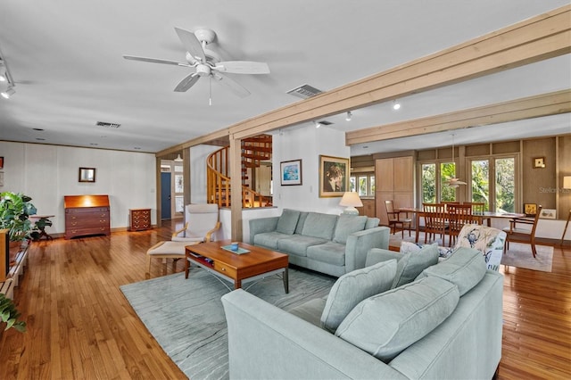 living room featuring stairway, hardwood / wood-style flooring, and visible vents