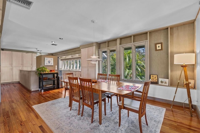 dining space featuring a ceiling fan, baseboards, visible vents, and hardwood / wood-style floors