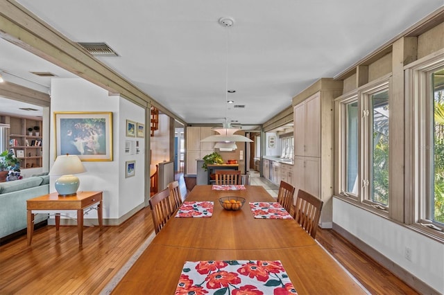 dining room with light wood-type flooring, baseboards, and visible vents