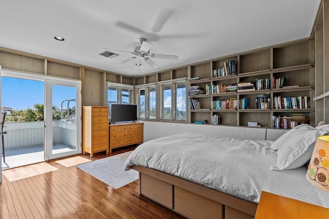 bedroom featuring access to outside, wood-type flooring, visible vents, and a ceiling fan