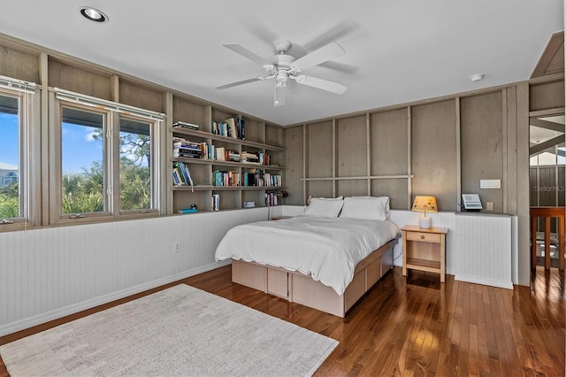 bedroom with a ceiling fan, radiator, and hardwood / wood-style flooring