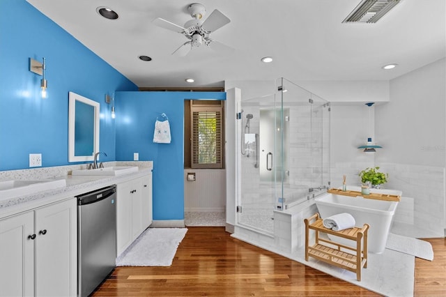 bathroom featuring a stall shower, visible vents, wood finished floors, vanity, and a freestanding tub