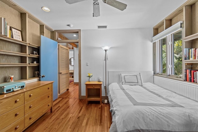 bedroom featuring light wood finished floors, ceiling fan, and visible vents