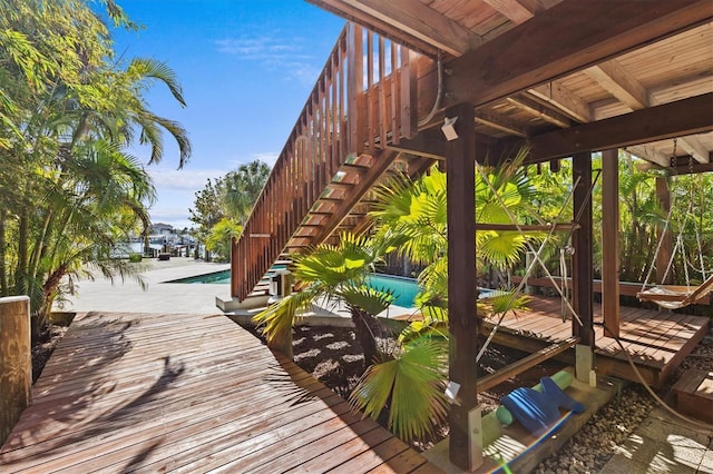 wooden terrace with stairs, a patio, and an outdoor pool