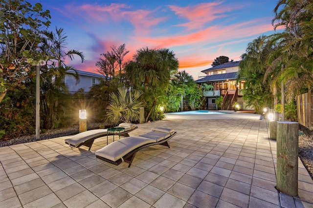 view of patio / terrace with stairs and an outdoor pool