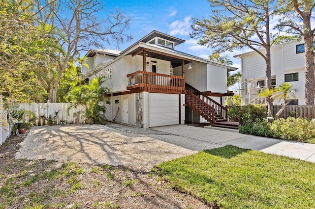 view of front of property featuring stairs, concrete driveway, fence, and a garage