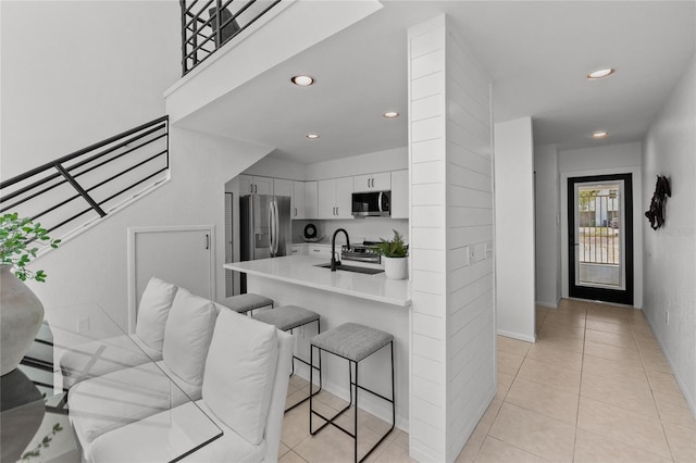 3101 W El Prado Blvd Unit B, Tampa, FL 33629 - kitchen featuring appliances with stainless steel finishes, a kitchen breakfast bar, a sink, recessed lighting, and light tile patterned floors