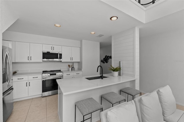 3101 W El Prado Blvd Unit B, Tampa, FL 33629 - kitchen with appliances with stainless steel finishes, a sink, a kitchen bar, a peninsula, and white cabinetry